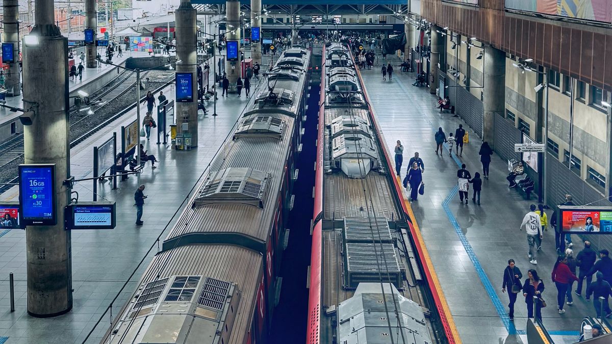 Busy São Paulo train station with passengers and trains